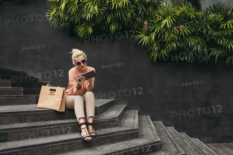 Caucasian woman using digital tablet on stairs