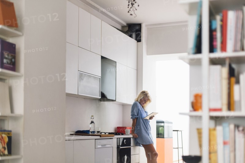 Woman using digital tablet in kitchen