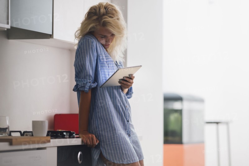 Woman using digital tablet in kitchen
