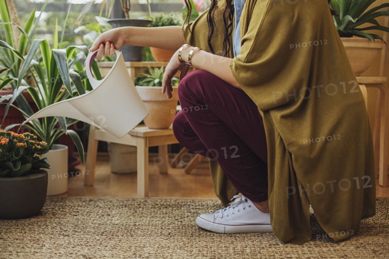 Caucasian woman watering potted plants