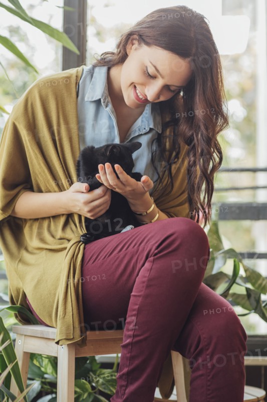 Caucasian woman holding kitten