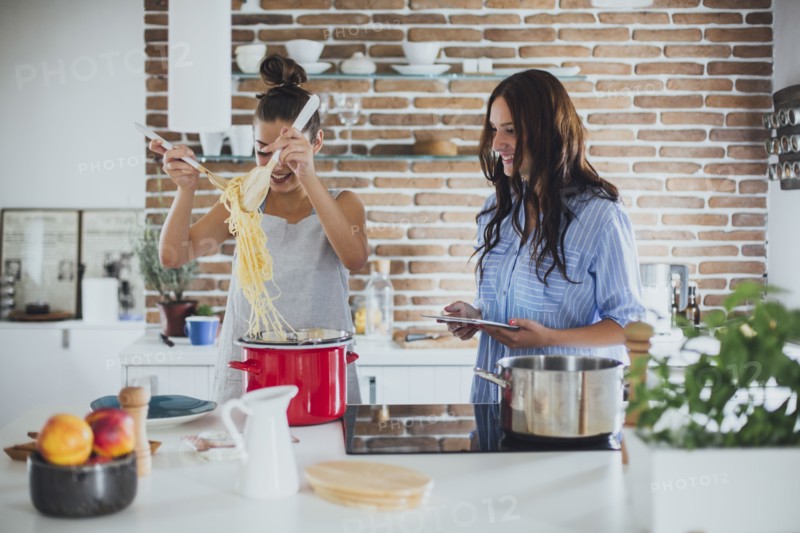 Caucasian women cooking pasta in kitchen