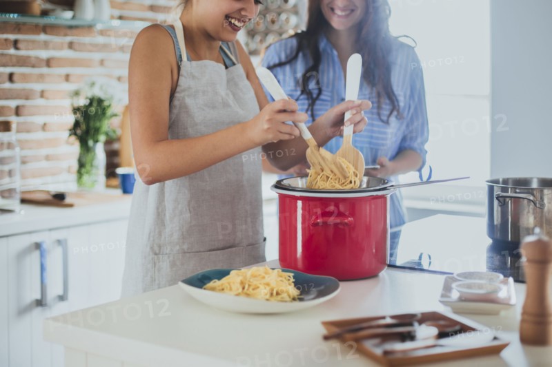 Caucasian women cooking pasta in kitchen
