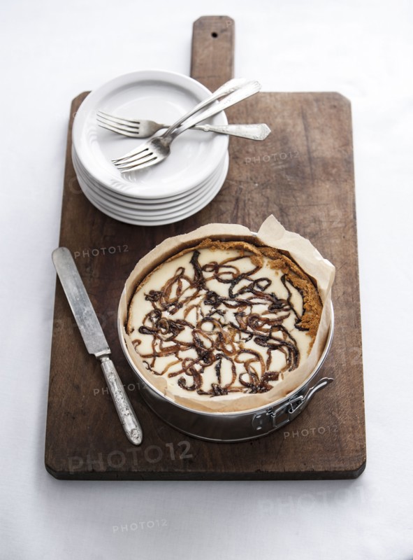 Onion cheesecake on cutting board with plates