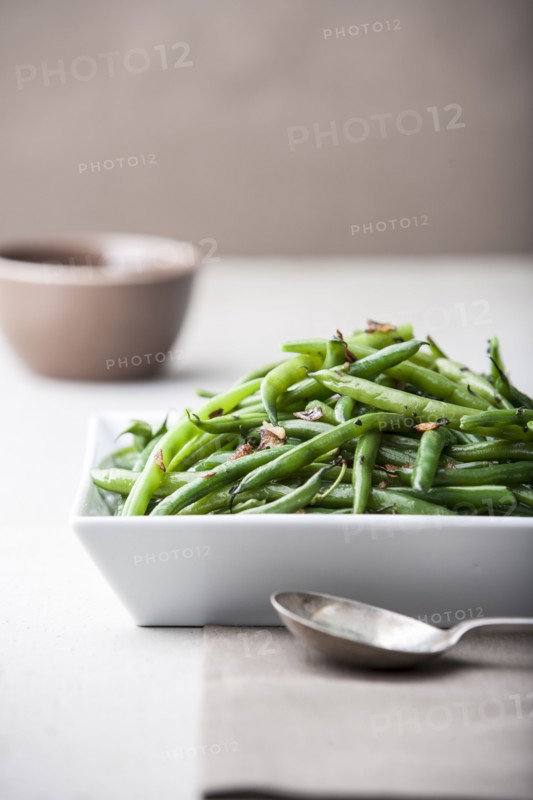 Pile of roasted green beans with spoon