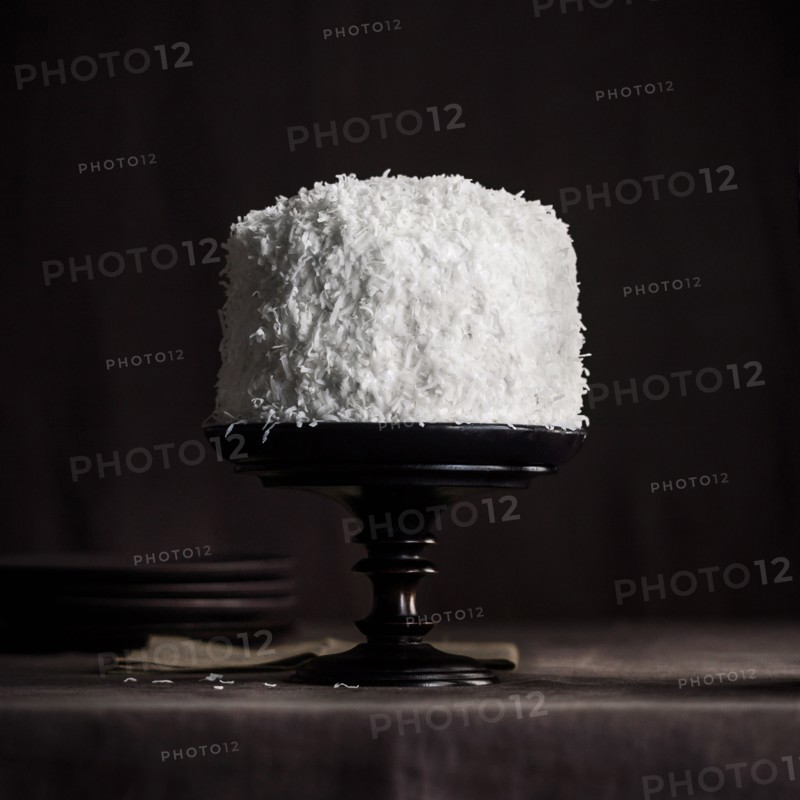 White coconut cake on black tray