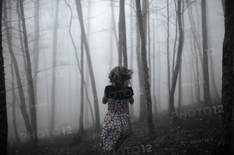 Caucasian woman running in forest