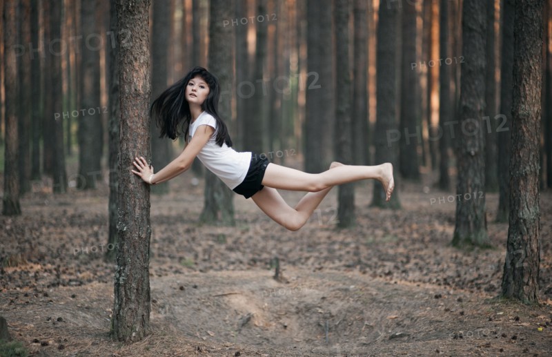 Caucasian woman floating in forest