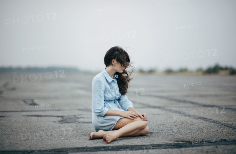 Caucasian woman sitting on concrete