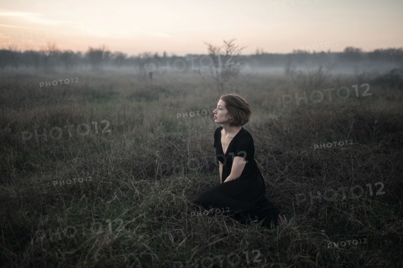 Caucasian woman sitting in remote field
