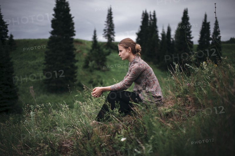 Caucasian woman sitting in remote field