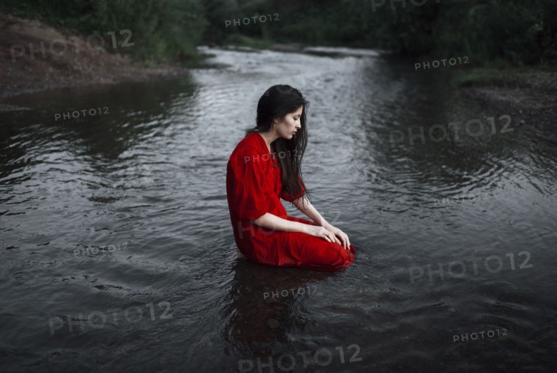 Caucasian woman sitting in remote stream