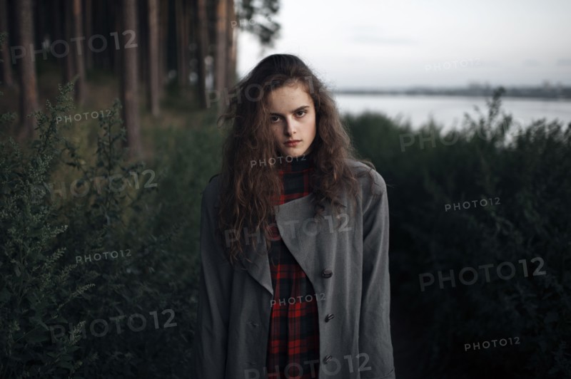 Caucasian woman standing in woods near lake