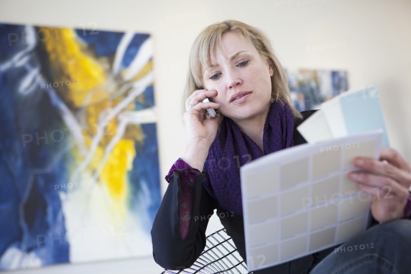 Caucasian art gallery owner talking on cell phone