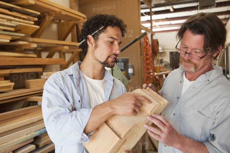 Co-workers woodworking in workshop