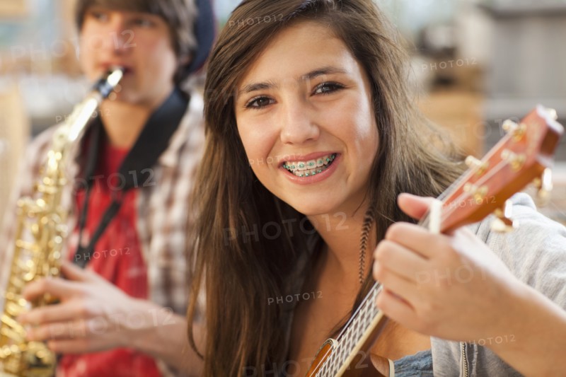 Mixed race girl playing guitar