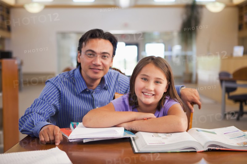 Teacher talking to student in library