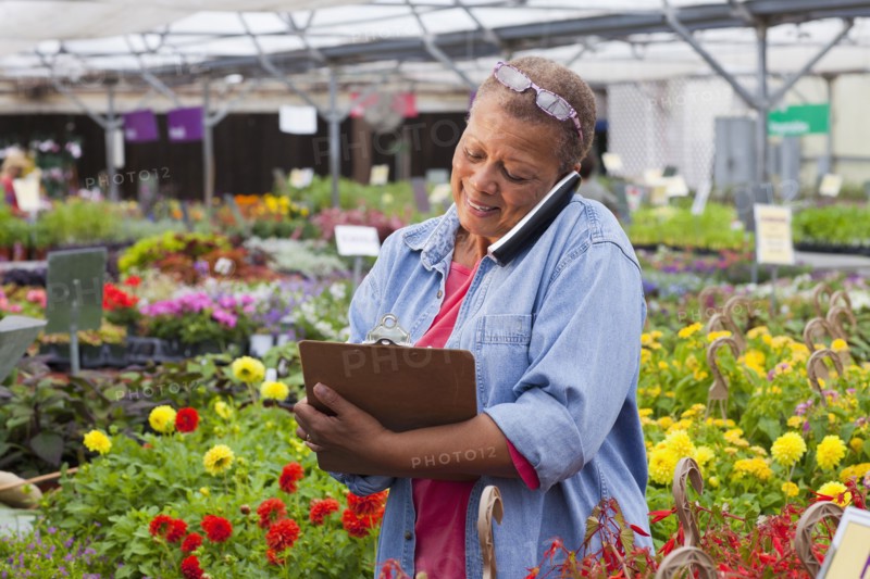 Mixed race woman talking on telephone in plant nursery