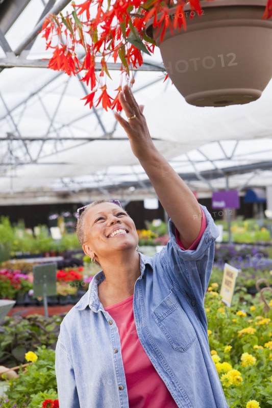 Mixed race woman tending plants in nursery