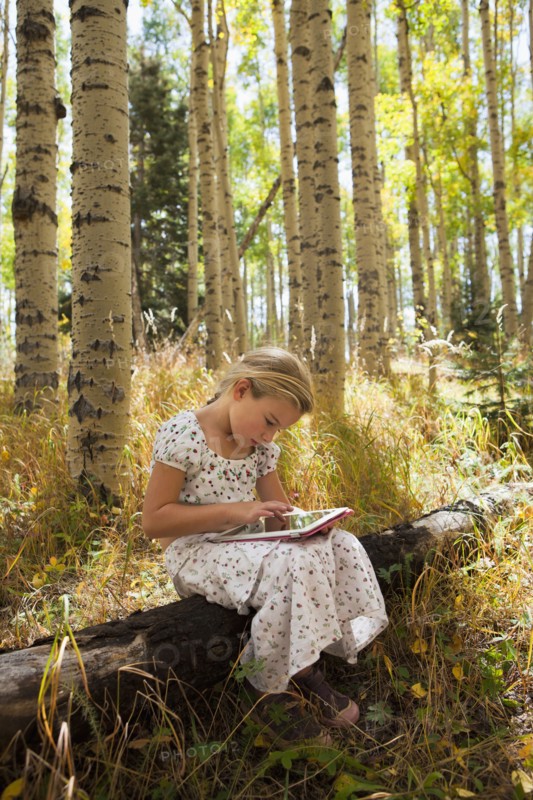 Caucasian girl using digital tablet in woods