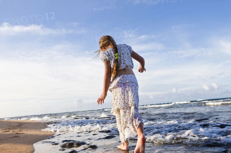 Caucasian girl walking on beach