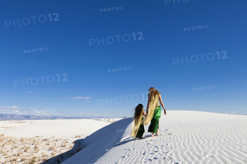 Caucasian mother and daughter walking in desert