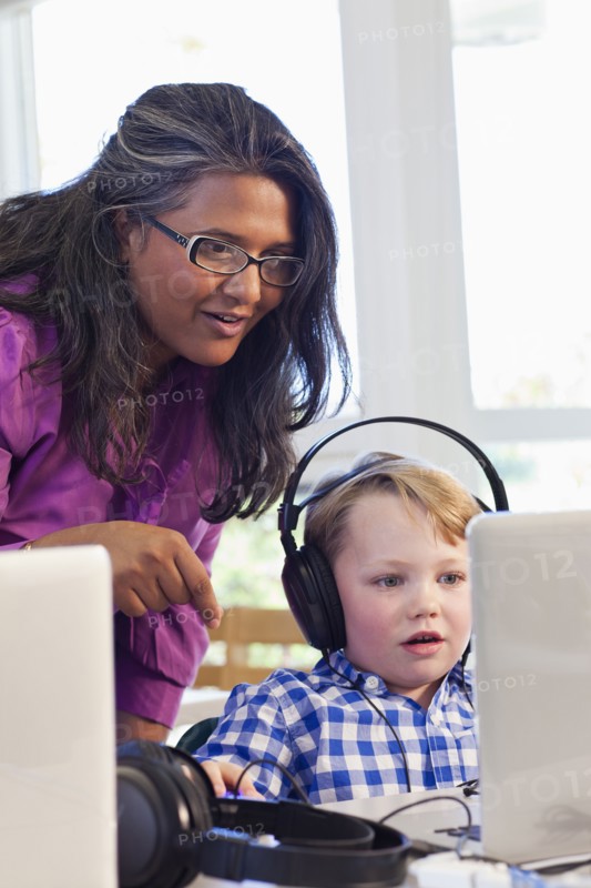 Teacher helping student using laptop
