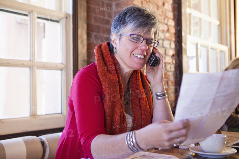Caucasian businesswoman on phone in cafe