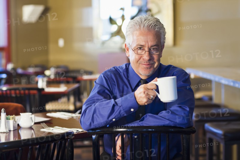 Hispanic cafe owner having cup of coffee