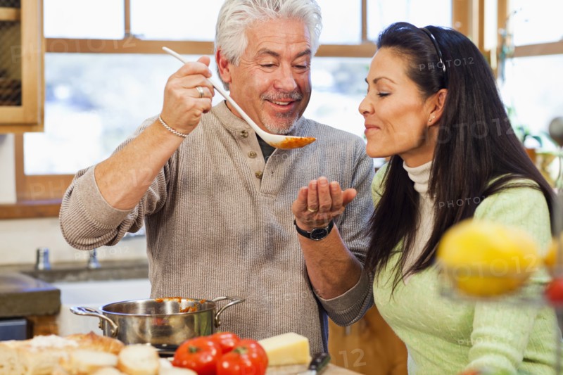 Hispanic couple cooking together in kitchen