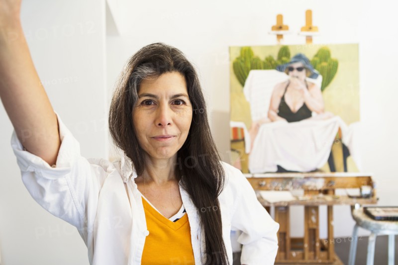 Hispanic artist smiling in studio