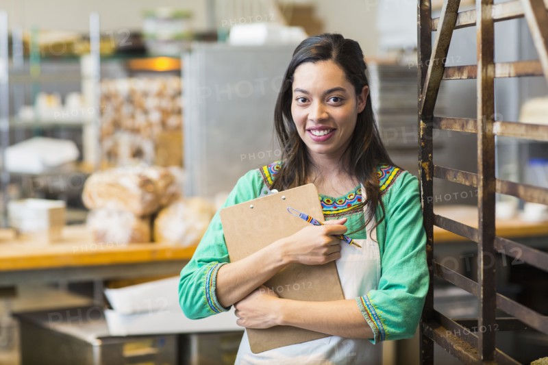 Mixed race woman working in bakery kitchen