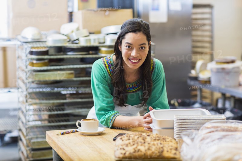 Mixed race woman working in bakery kitchen