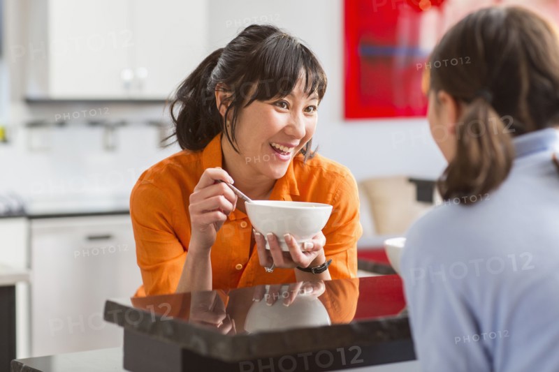 Mother and daughter talking in kitchen