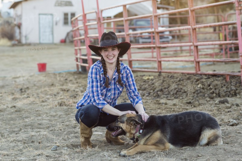 Caucasian girl petting dog on farm