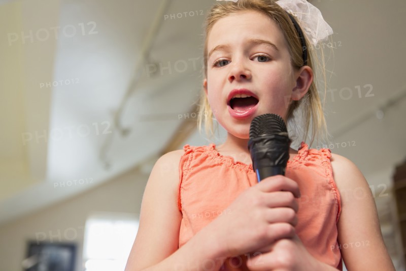 Caucasian girl singing karaoke at home