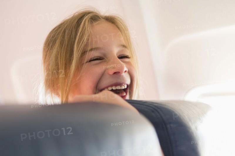 Caucasian girl laughing on airplane