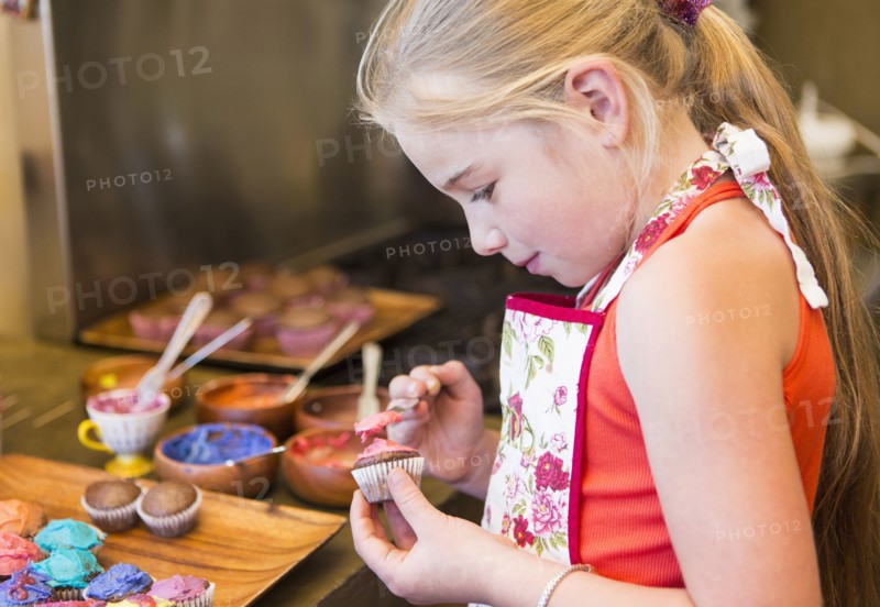 Caucasian girl making cupcakes