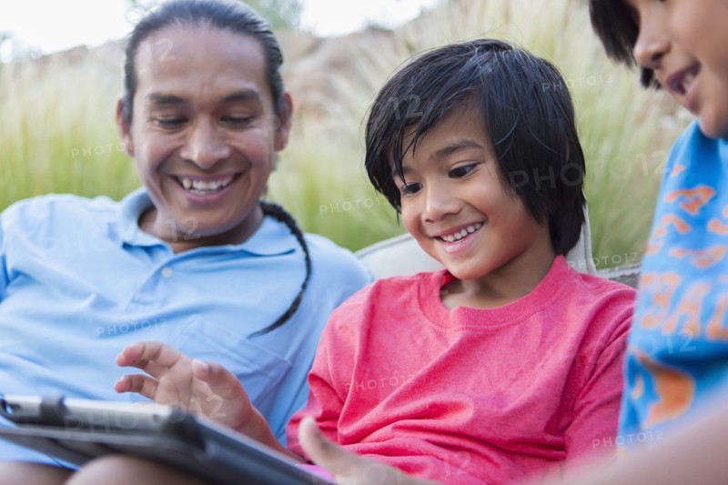 Family using digital tablet outdoors