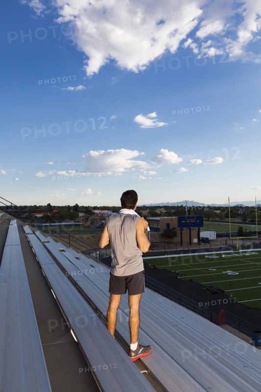 Hispanic athlete standing on bleachers