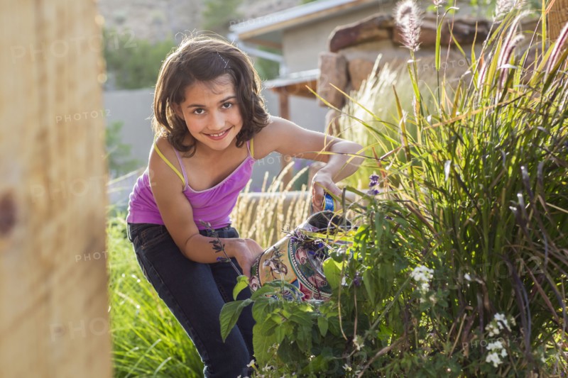 Girl watering plants in garden