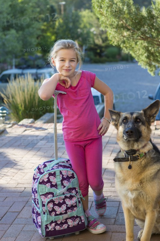 Caucasian girl with suitcase and dog outdoors