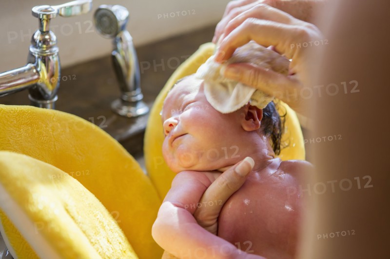 Caucasian newborn baby boy having bath