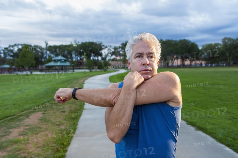 Hispanic man stretching in park