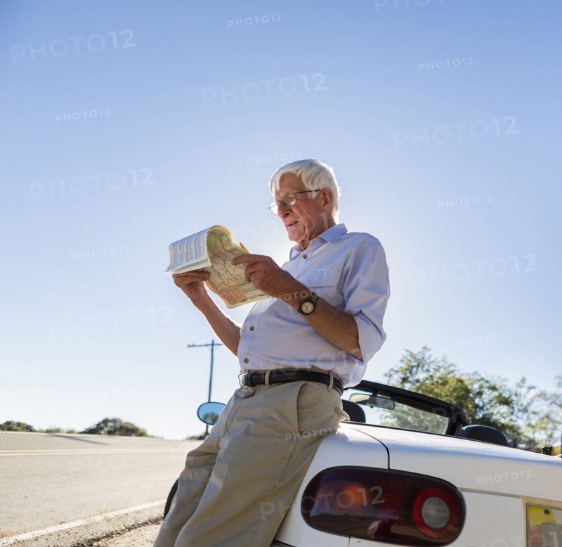 Senior Caucasian man reading map by road