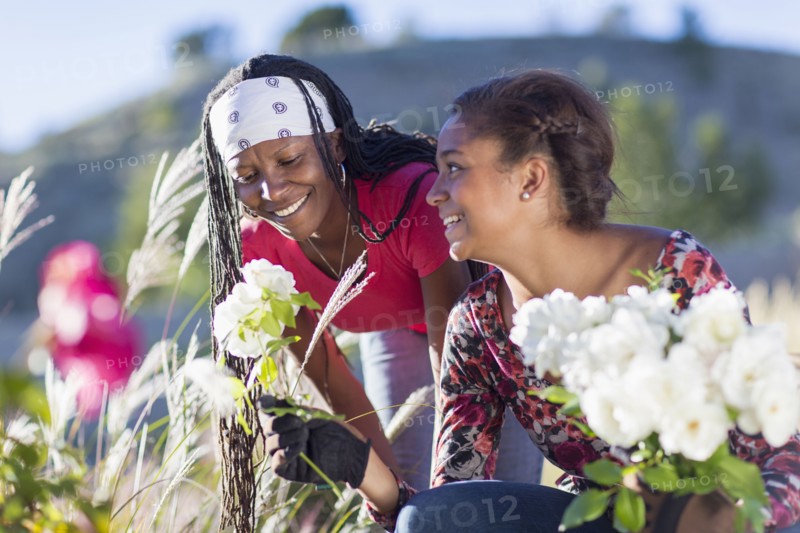 Mother and daughter picking flowers outdoors