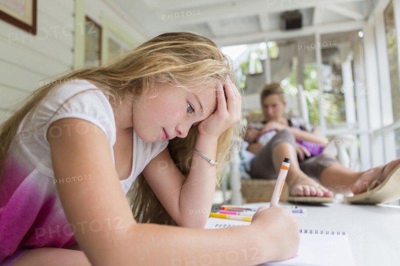 Caucasian mother and daughter relaxing on sun porch