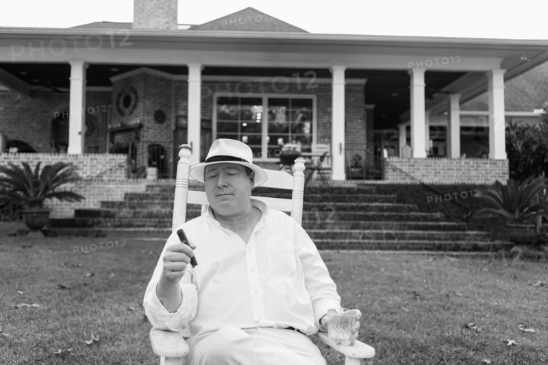 Caucasian man relaxing with cigar in yard