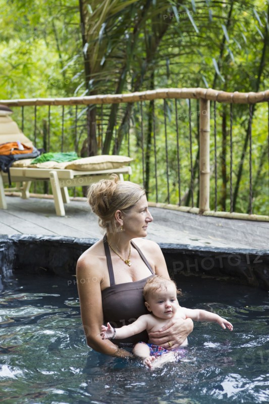 Caucasian mother and baby relaxing in pool