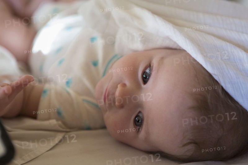 Caucasian baby boy laying on bed